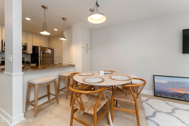 dining area with light wood-type flooring and sink