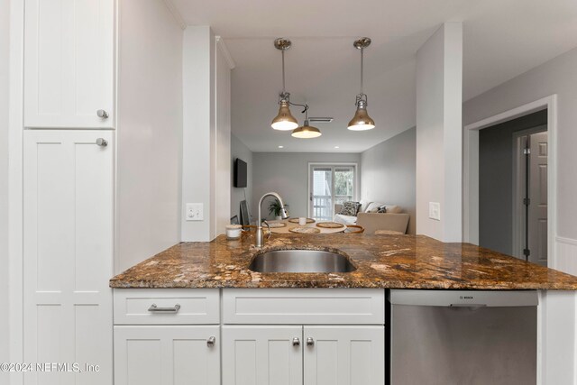 kitchen featuring white cabinetry, sink, dark stone counters, and decorative light fixtures