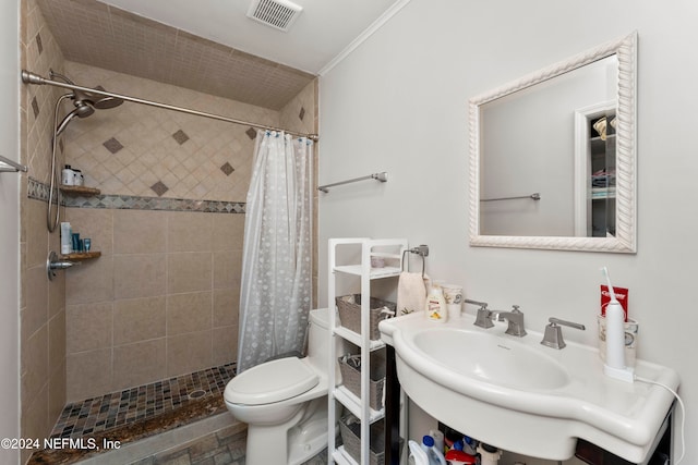 bathroom with a shower with curtain, toilet, and crown molding