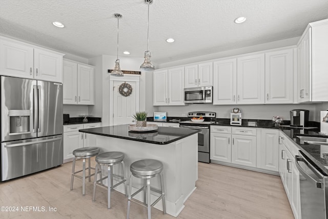 kitchen featuring white cabinetry, a kitchen island, stainless steel appliances, and a textured ceiling