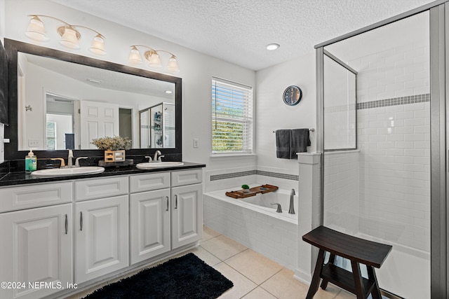 bathroom featuring vanity, a textured ceiling, tile patterned floors, and independent shower and bath