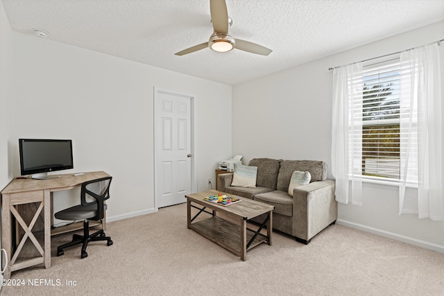 office featuring a textured ceiling, light colored carpet, and ceiling fan