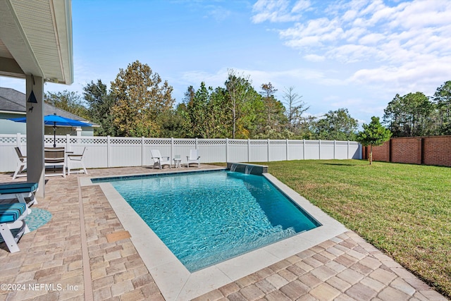 view of pool featuring a lawn, a patio area, and pool water feature