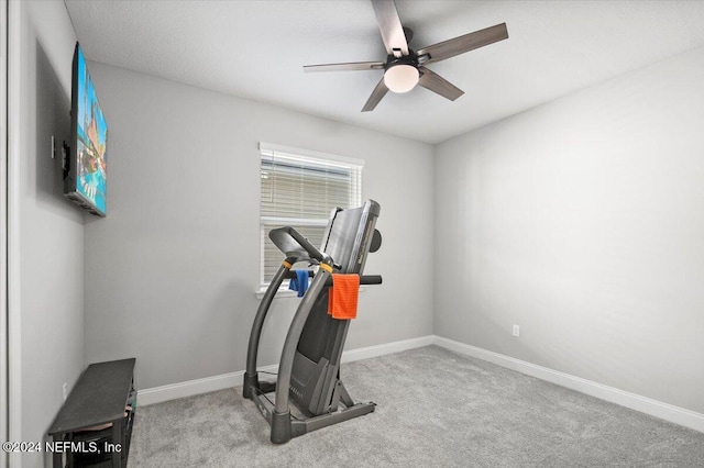 workout room with ceiling fan and light colored carpet