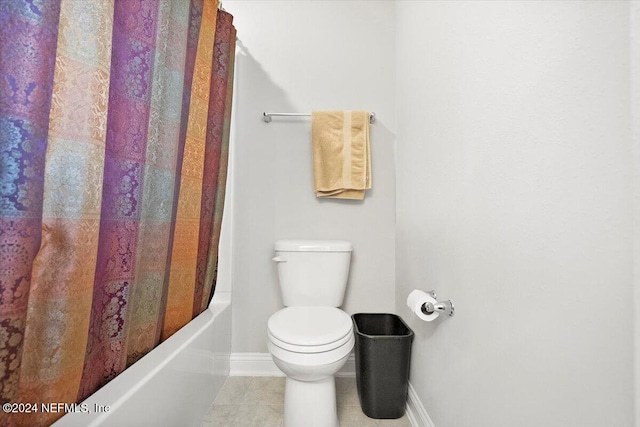 bathroom featuring tile patterned flooring, shower / bath combination with curtain, and toilet