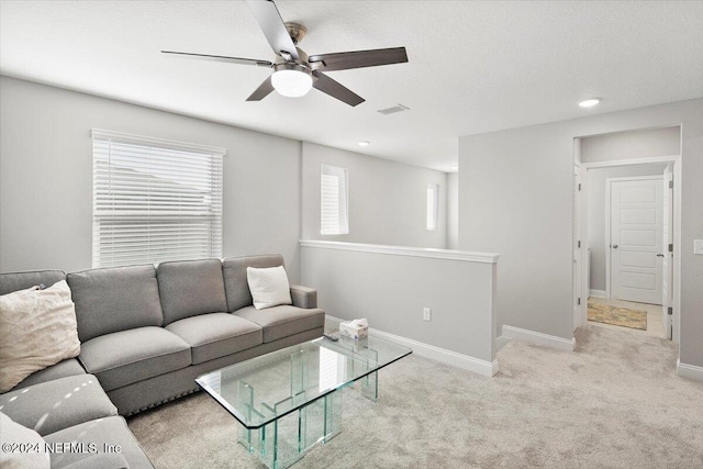 carpeted living room with ceiling fan