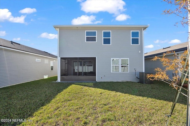 rear view of property with a sunroom, cooling unit, and a lawn