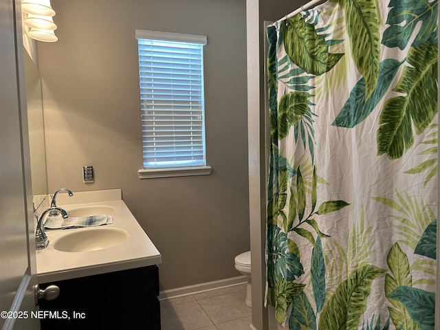 full bathroom with a wealth of natural light, tile patterned flooring, double vanity, and toilet