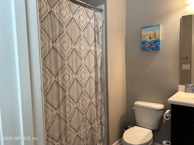 full bath with a textured wall, vanity, a shower with curtain, and toilet