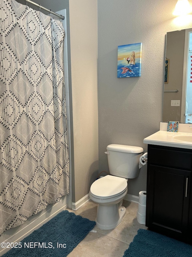 full bathroom featuring toilet, tile patterned floors, vanity, and baseboards
