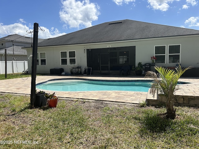 rear view of property featuring a shingled roof, fence, a patio, stucco siding, and an outdoor pool