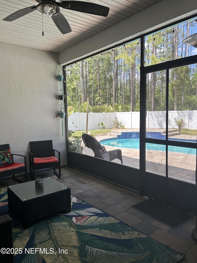 sunroom featuring a ceiling fan