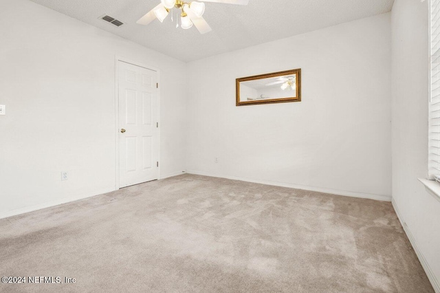 carpeted empty room with ceiling fan and a textured ceiling