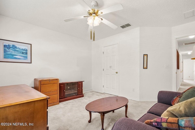 carpeted living room with a textured ceiling and ceiling fan