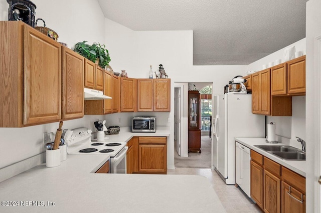 kitchen featuring a textured ceiling, white appliances, and sink