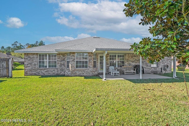 back of property with a lawn and a patio area