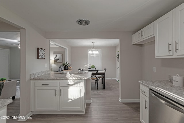 kitchen featuring white cabinets, ceiling fan with notable chandelier, hanging light fixtures, stainless steel dishwasher, and hardwood / wood-style flooring