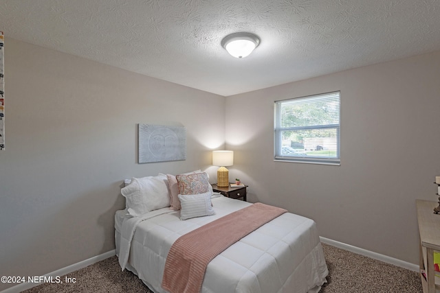 bedroom featuring carpet flooring and a textured ceiling