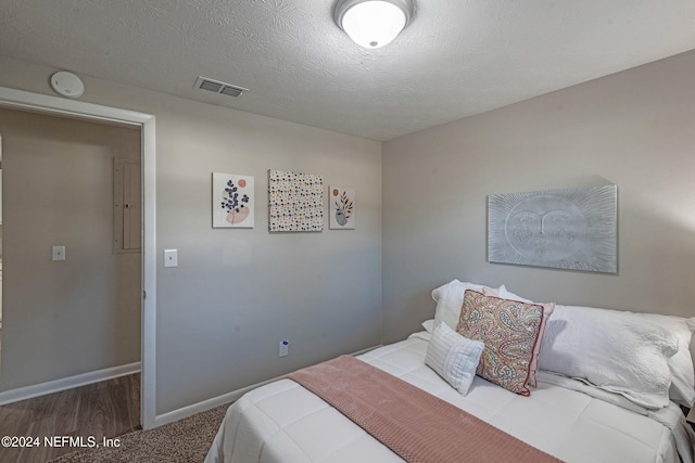 bedroom featuring a textured ceiling and dark wood-type flooring