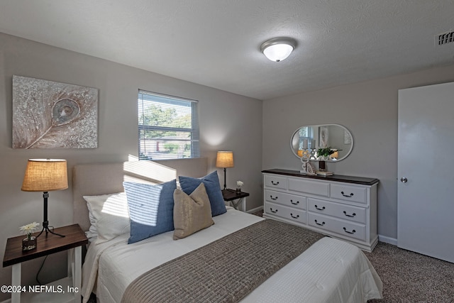 bedroom with carpet floors and a textured ceiling