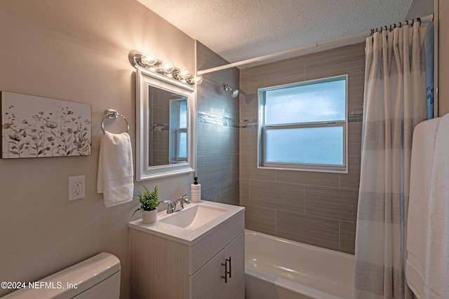 full bathroom featuring vanity, shower / bath combination with curtain, a textured ceiling, and toilet