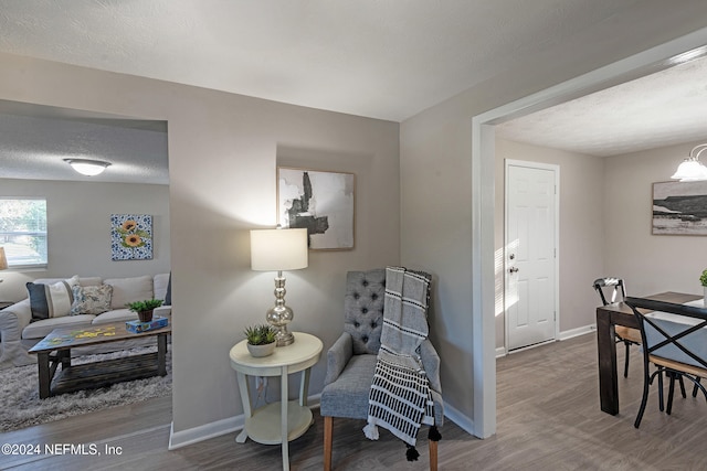 sitting room featuring a chandelier, a textured ceiling, and hardwood / wood-style flooring