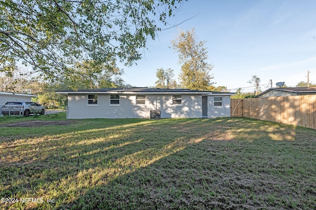 rear view of property with a yard