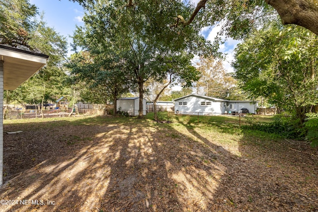 view of yard featuring a playground and a storage unit