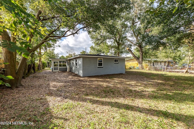 view of side of property featuring a yard and a sunroom