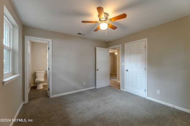 unfurnished bedroom featuring carpet flooring, ensuite bath, and ceiling fan