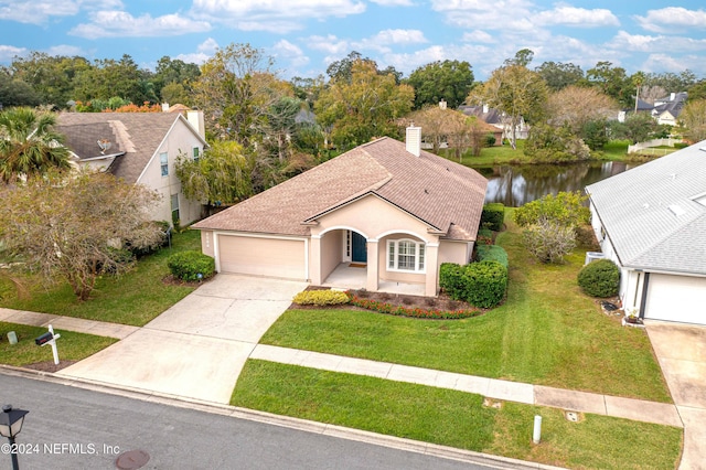 view of front facade with a water view, a front yard, and a garage