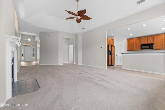 unfurnished living room featuring ceiling fan and light colored carpet