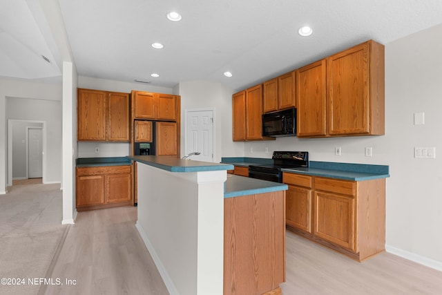 kitchen with light wood-type flooring, a center island with sink, vaulted ceiling, and black appliances