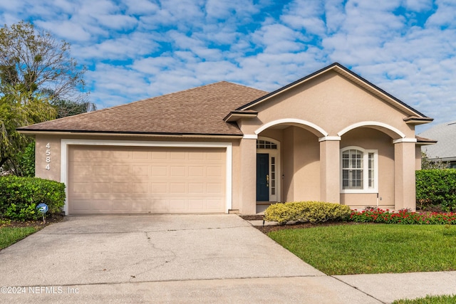 view of front of house featuring a garage and a front lawn