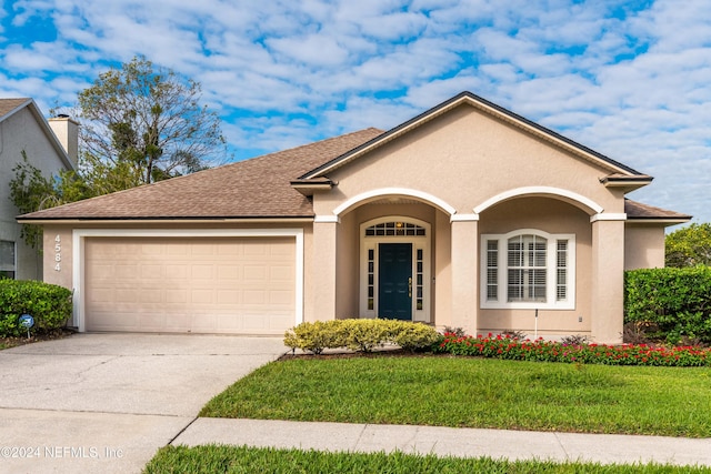 ranch-style home with a front lawn and a garage