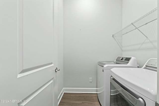 washroom with dark wood-type flooring and washing machine and clothes dryer