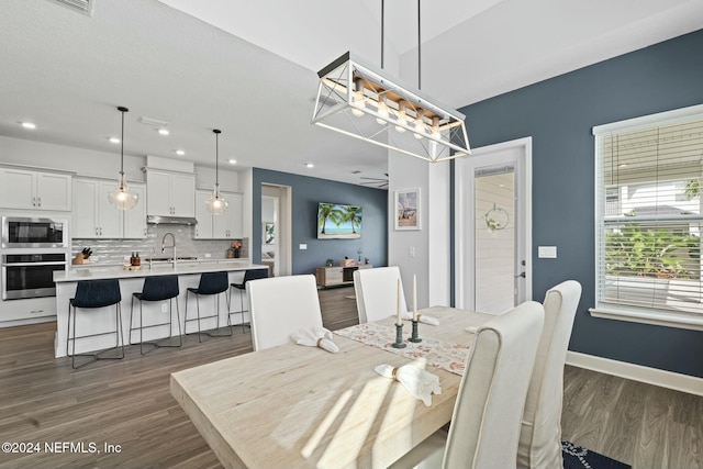 dining space with ceiling fan, dark hardwood / wood-style floors, and sink