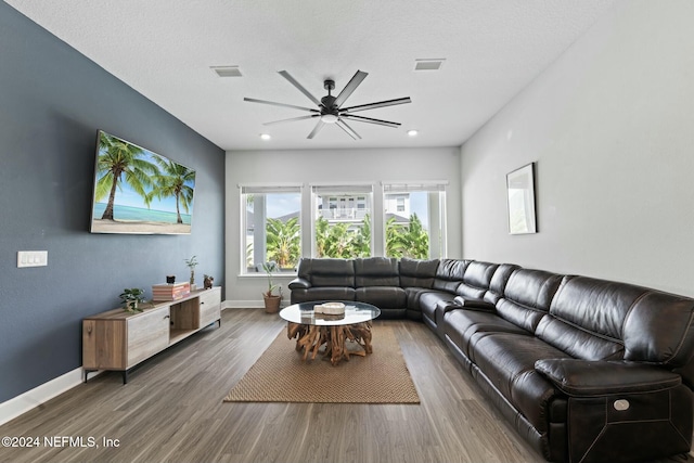 living room with a textured ceiling, dark hardwood / wood-style floors, and ceiling fan