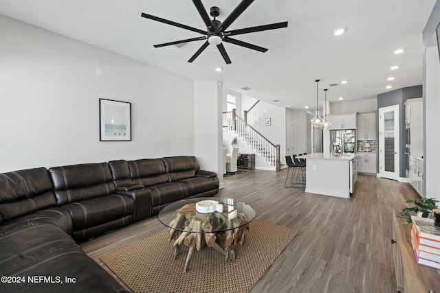 living room with ceiling fan and dark hardwood / wood-style flooring