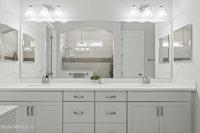 bathroom with a tile shower and vanity