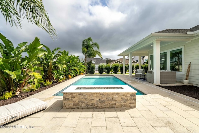 view of pool featuring an outdoor living space with a fire pit and a patio