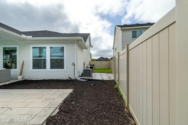 view of property exterior with cooling unit and a patio area