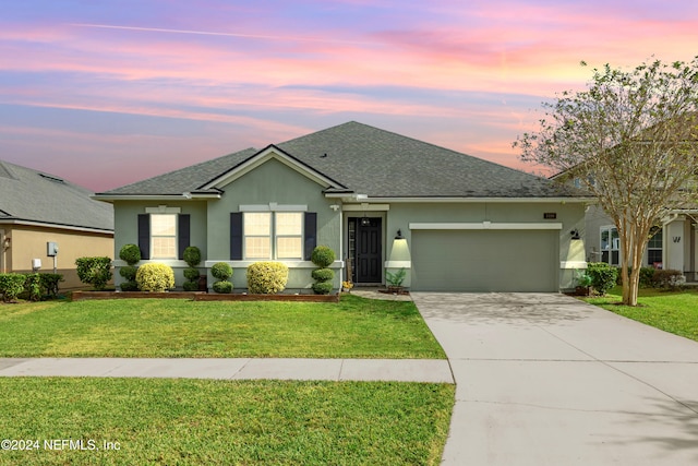 view of front of home with a yard and a garage