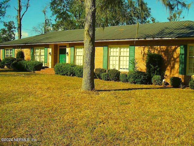 1113 Fieldcrest Rd, Jasper, FL 32052 - ranch-style home with a front yard, a metal roof, and brick siding