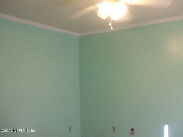 empty room with ceiling fan and crown molding