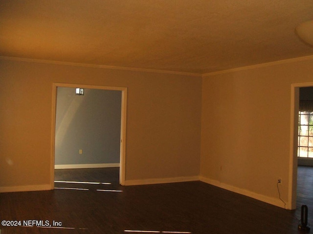 unfurnished room with crown molding and dark hardwood / wood-style flooring