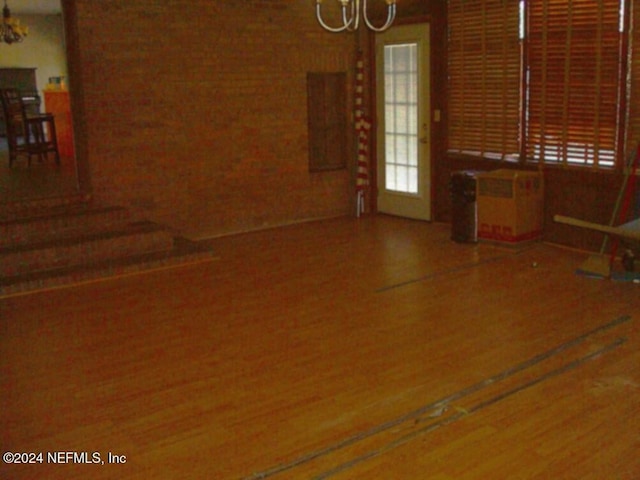 spare room featuring wood-type flooring and an inviting chandelier