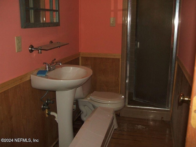 bathroom with wood-type flooring, toilet, and walk in shower