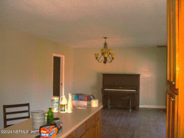 dining area featuring dark colored carpet and a notable chandelier