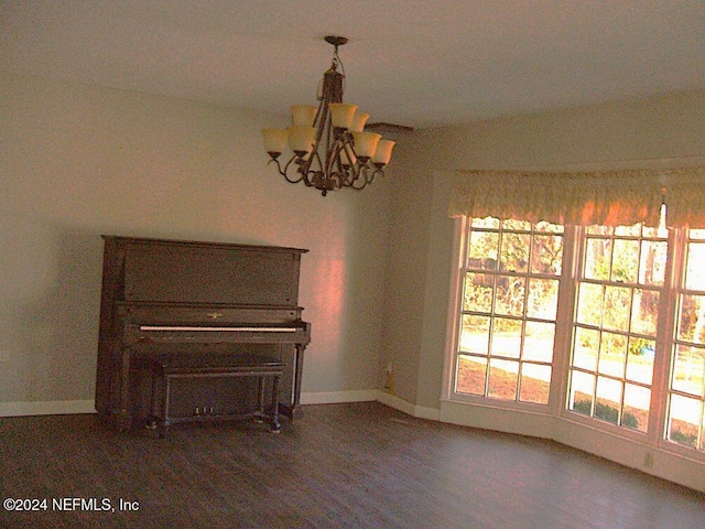 unfurnished dining area featuring dark wood-type flooring and a chandelier